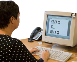 Foto van logopedist achter een computerscherm.