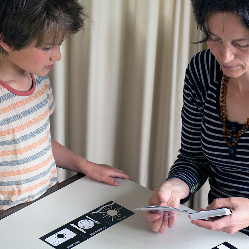 Foto van leraar en leerlingen, samen aan de slag met pictokaartjes.